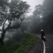 "Motorcyclist riding through monsoon rain on Indian highway"