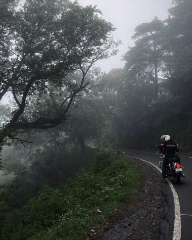 "Motorcyclist riding through monsoon rain on Indian highway"