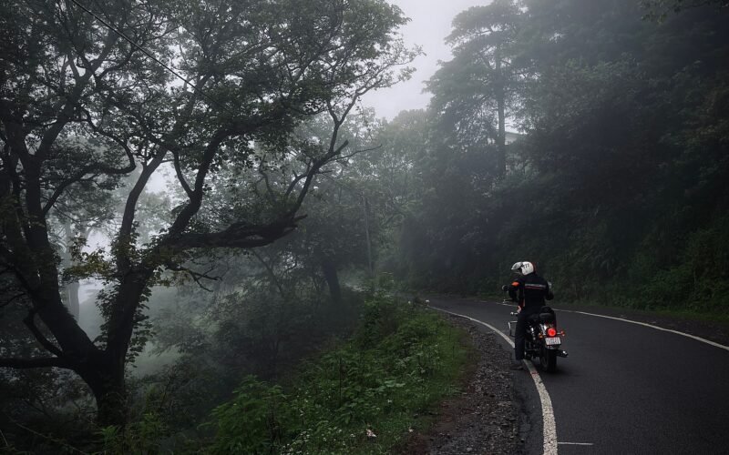"Motorcyclist riding through monsoon rain on Indian highway"